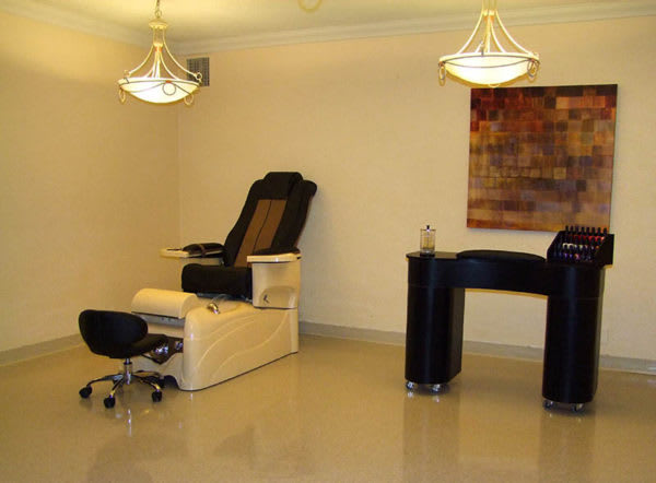 A modern nail salon with a comfortable spa chair and manicure station.