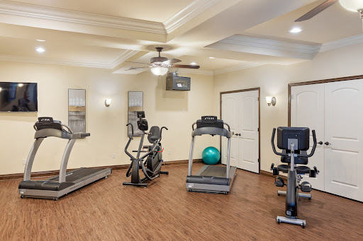 A modern gym facility equipped with various exercise machines and a workout ball.