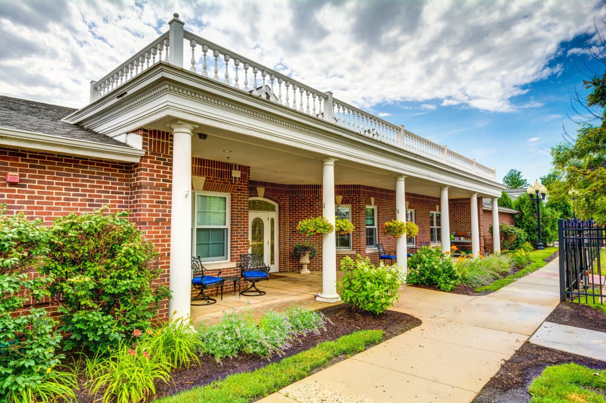 A charming brick house with a welcoming front porch and well-maintained landscaping.