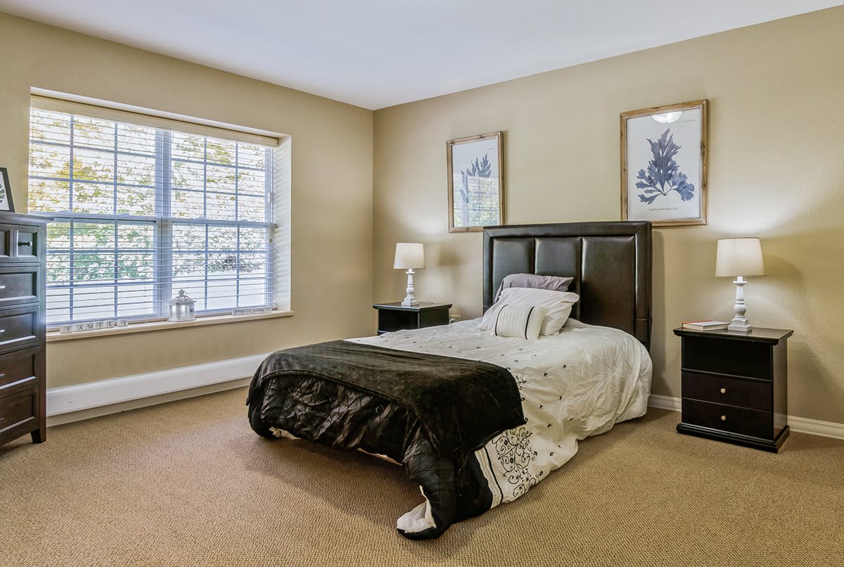 A cozy bedroom with a neatly made bed and minimalist decor.