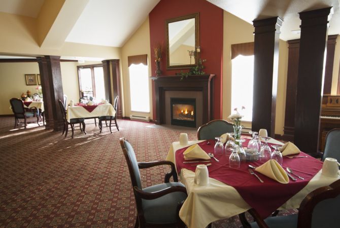 An elegantly set dining room with a fireplace adding warmth and ambiance.