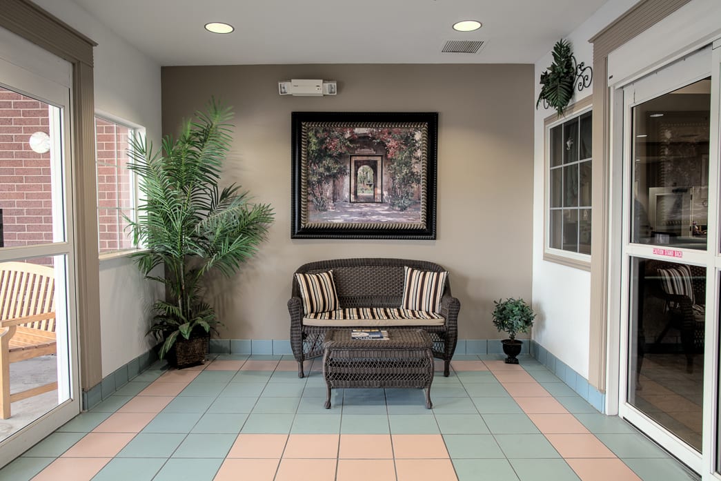 A cozy lobby area with a bench and artwork on the wall.