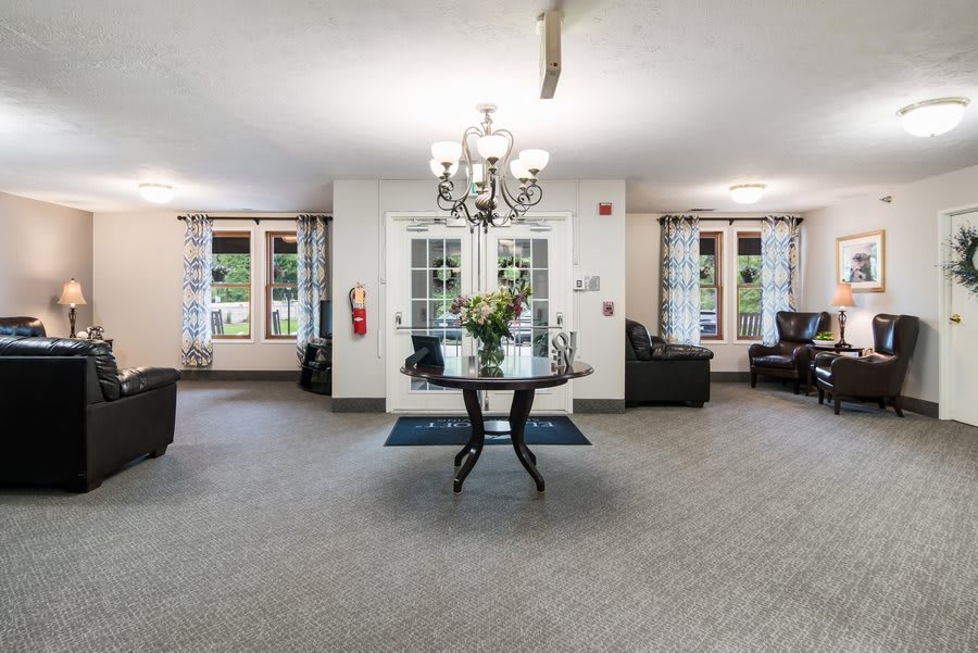 A spacious and elegantly designed lobby with a central table under a chandelier.