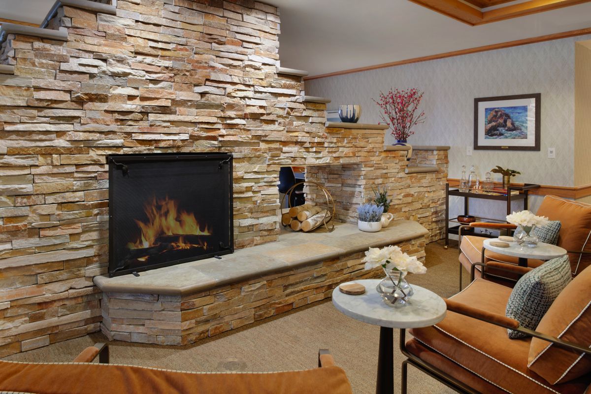 A cozy living room features a stone fireplace and comfortable seating area.
