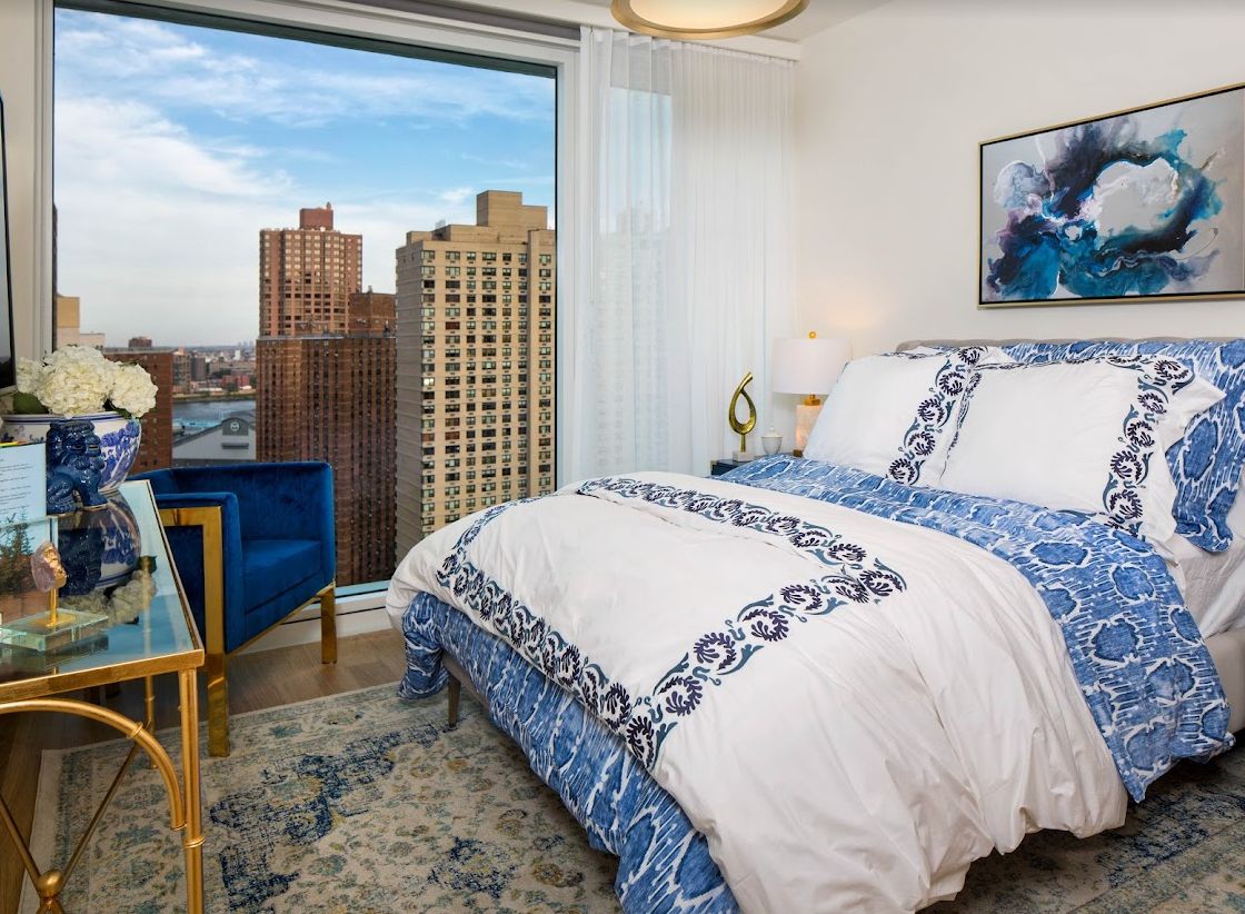 A cozy bedroom with a city view and stylish decor.