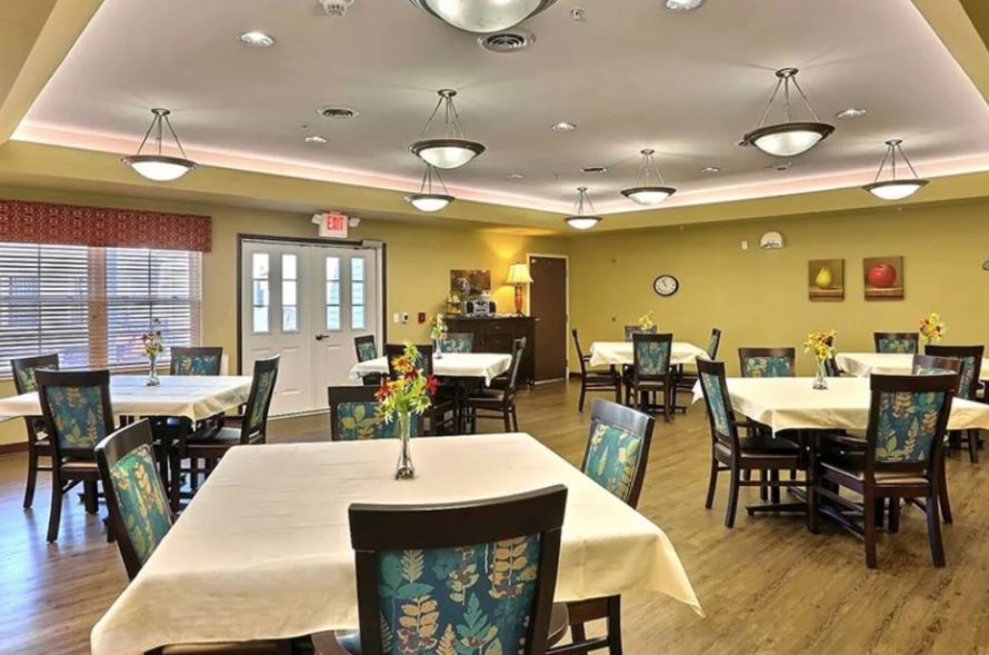 A well-lit dining room with neatly arranged tables and chairs, featuring a cozy and inviting atmosphere.