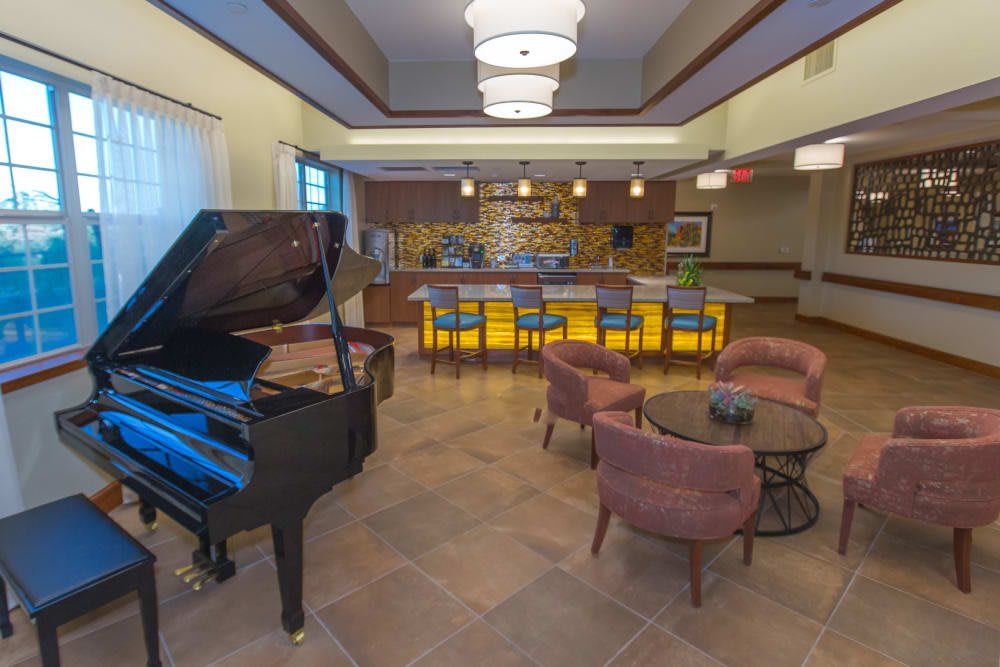 A cozy indoor bar area featuring a grand piano and comfortable seating.