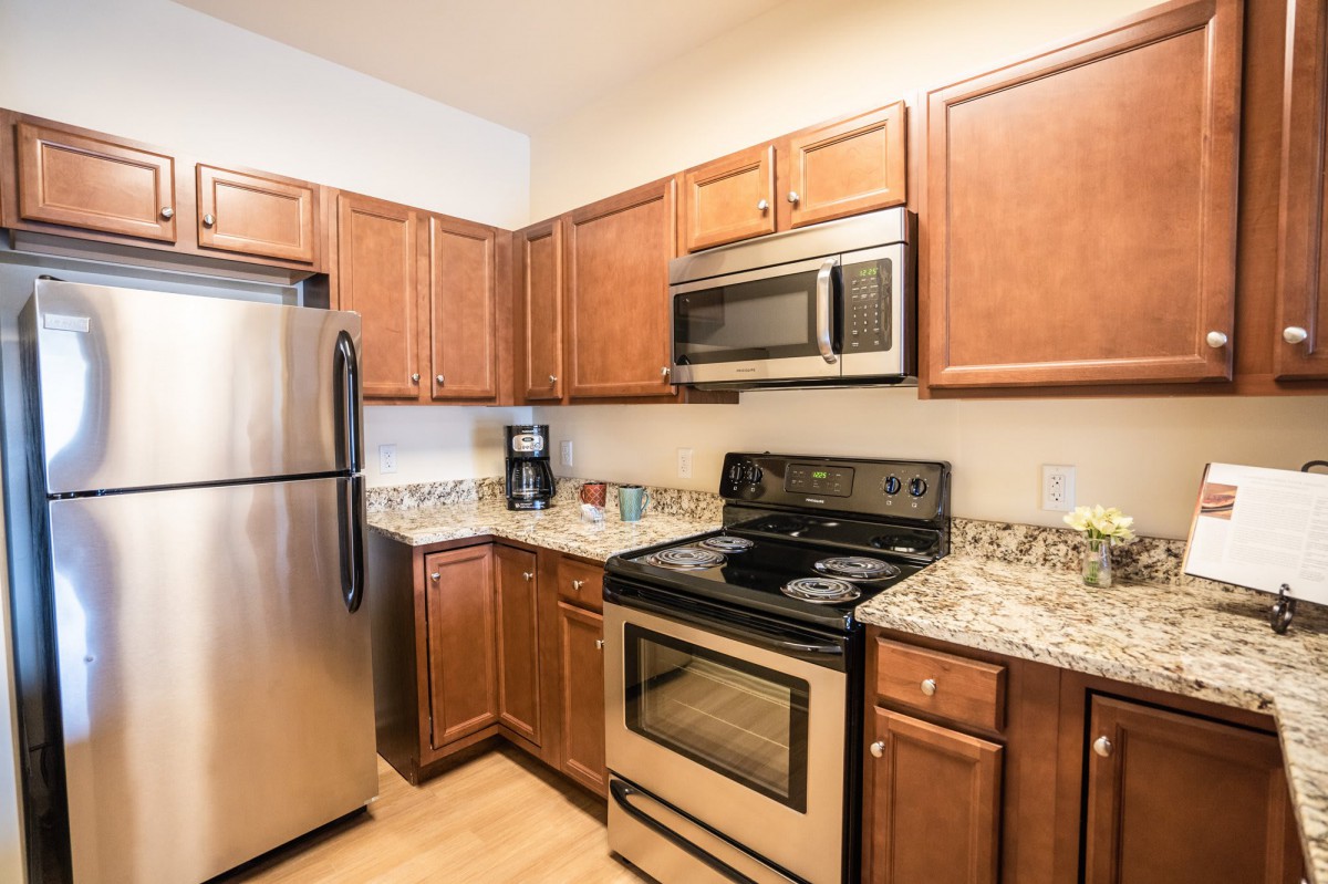 A modern kitchen with stainless steel appliances and wooden cabinets.