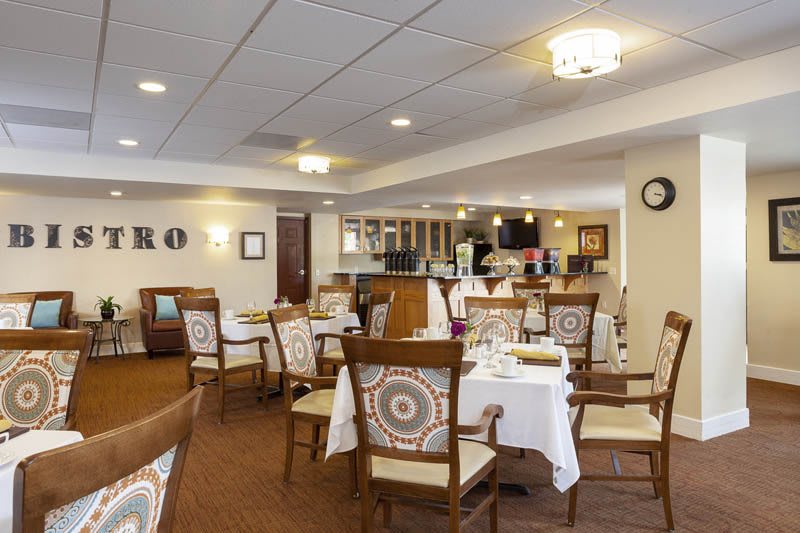 A cozy and well-decorated restaurant dining room with empty tables and chairs.