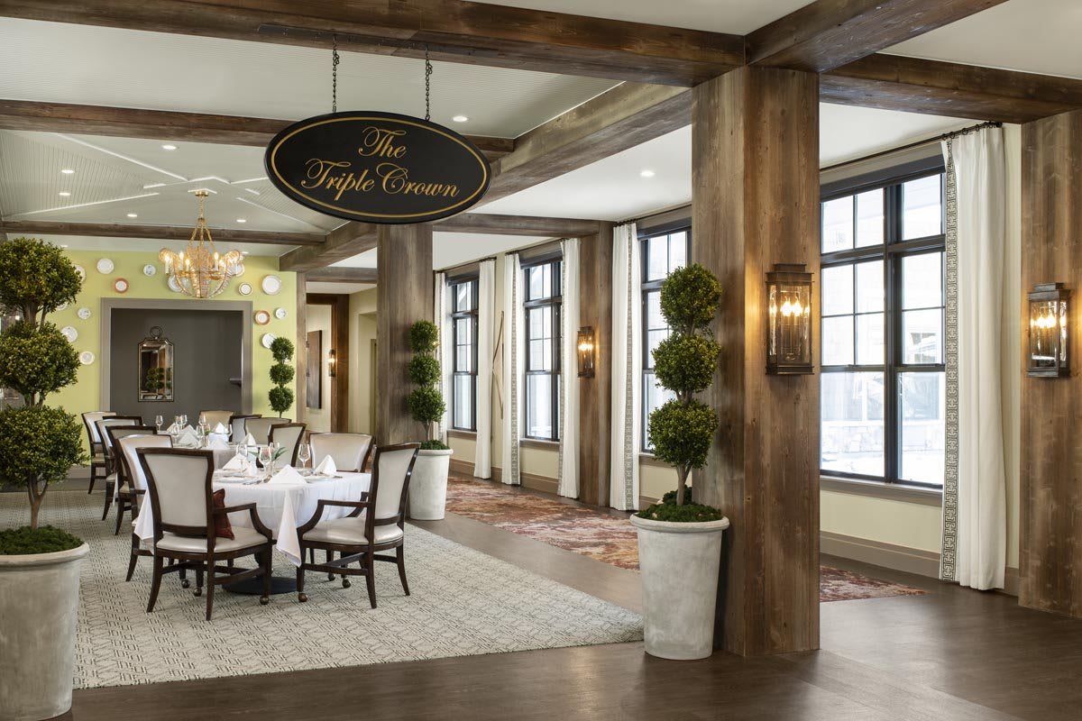 An elegant restaurant interior with large windows and a neatly arranged dining area.