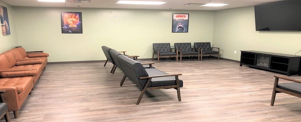 A spacious waiting room with modern seating and a poster on the wall.