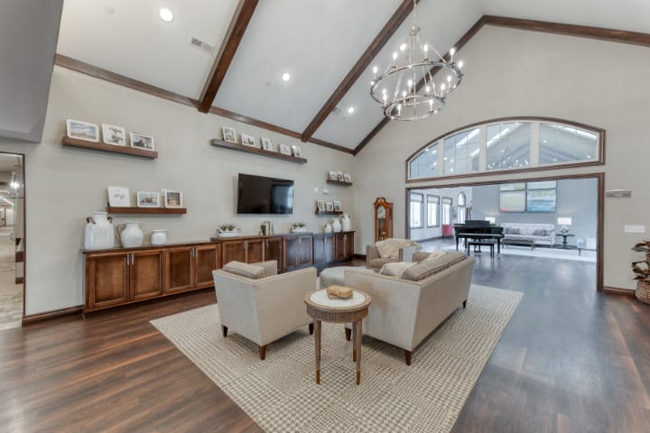 A modern living room with high ceilings, a chandelier, and sophisticated decor.