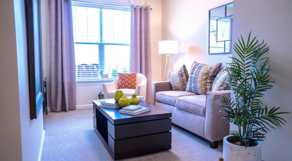 A stylishly decorated living room featuring a comfortable sofa, coffee table, and elegant lighting.
