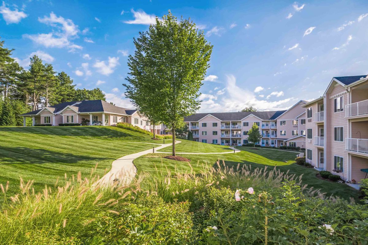 A serene residential complex surrounded by greenery and a clear blue sky.