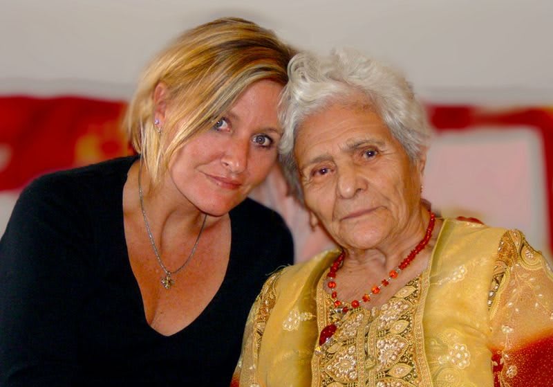 A younger woman and an elderly woman posing together for a photo.