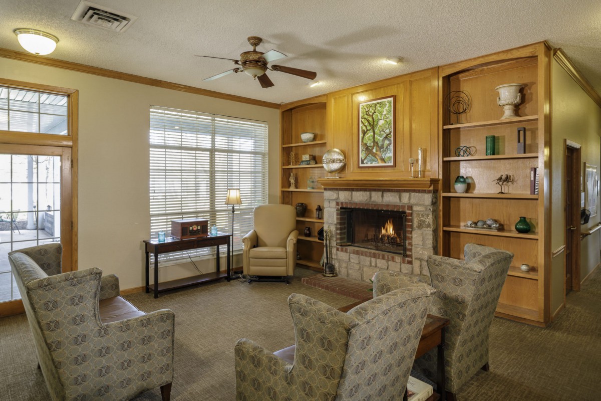 Cozy living room with a fireplace, armchairs, and built-in bookshelves.