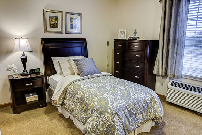 A cozy bedroom with neatly arranged furniture and a comfortable bed.