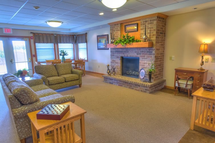 A cozy living room with a brick fireplace and comfortable seating.