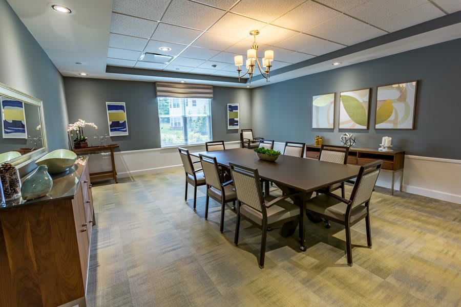 A modern dining room with a large table and chairs, featuring contemporary decor and natural light.