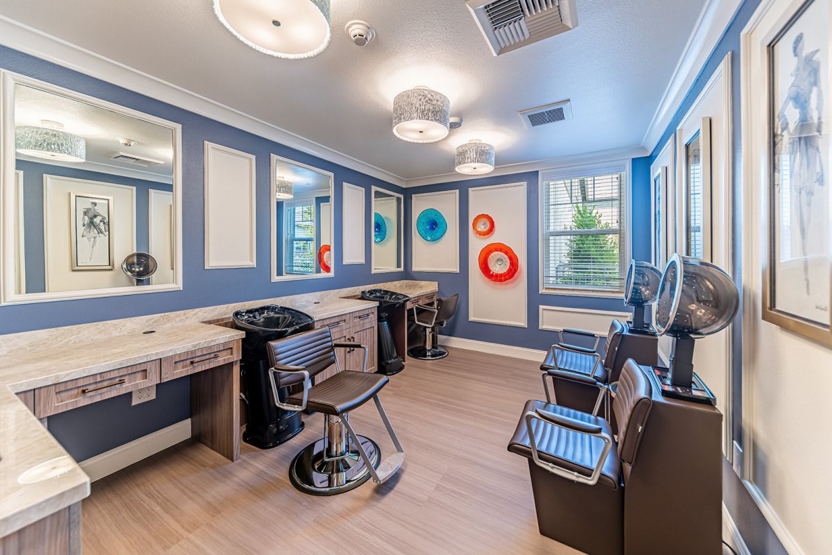 A modern hair salon interior with styling chairs, mirrors, and colorful wall decor.
