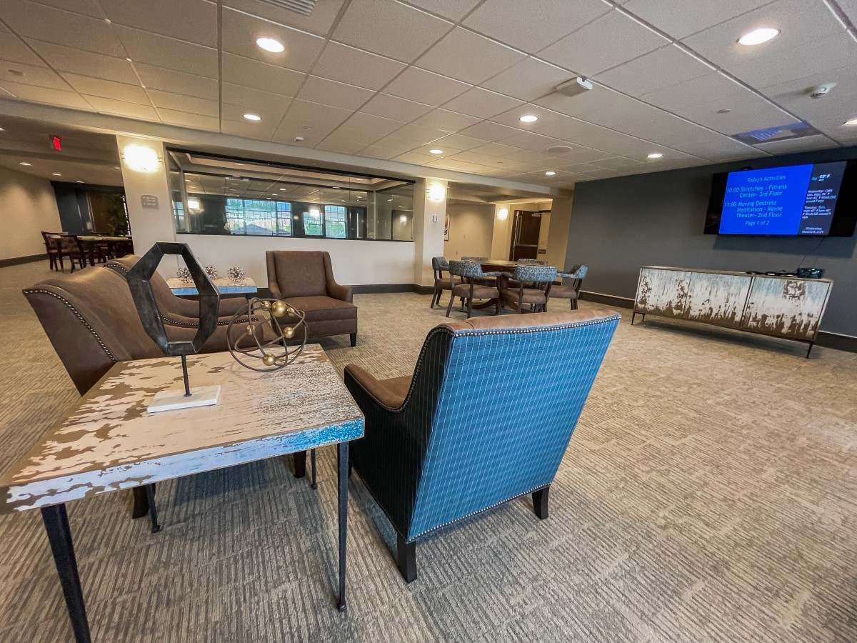 A modern lounge area with comfortable seating and a large television.