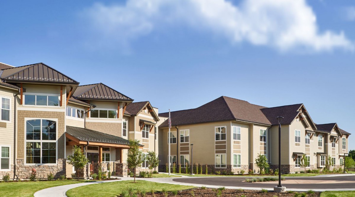 A modern residential apartment complex under a clear blue sky.