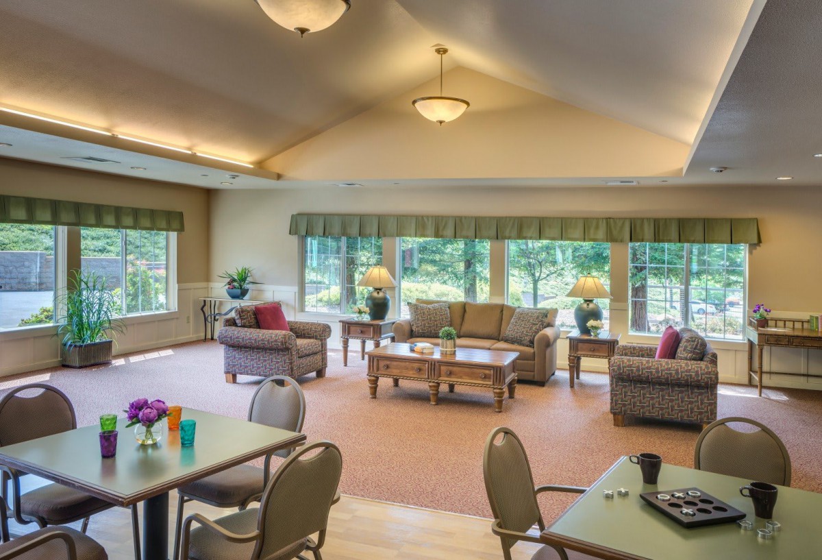 A spacious and well-lit living room with comfortable seating and large windows.