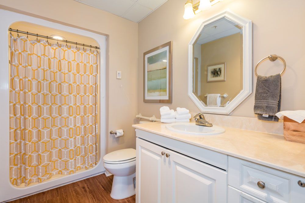 A neatly arranged bathroom with a shower, sink, and toilet.