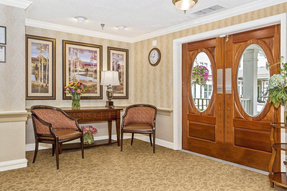 A cozy lobby area with chairs, a table, and decorative artwork on the walls.
