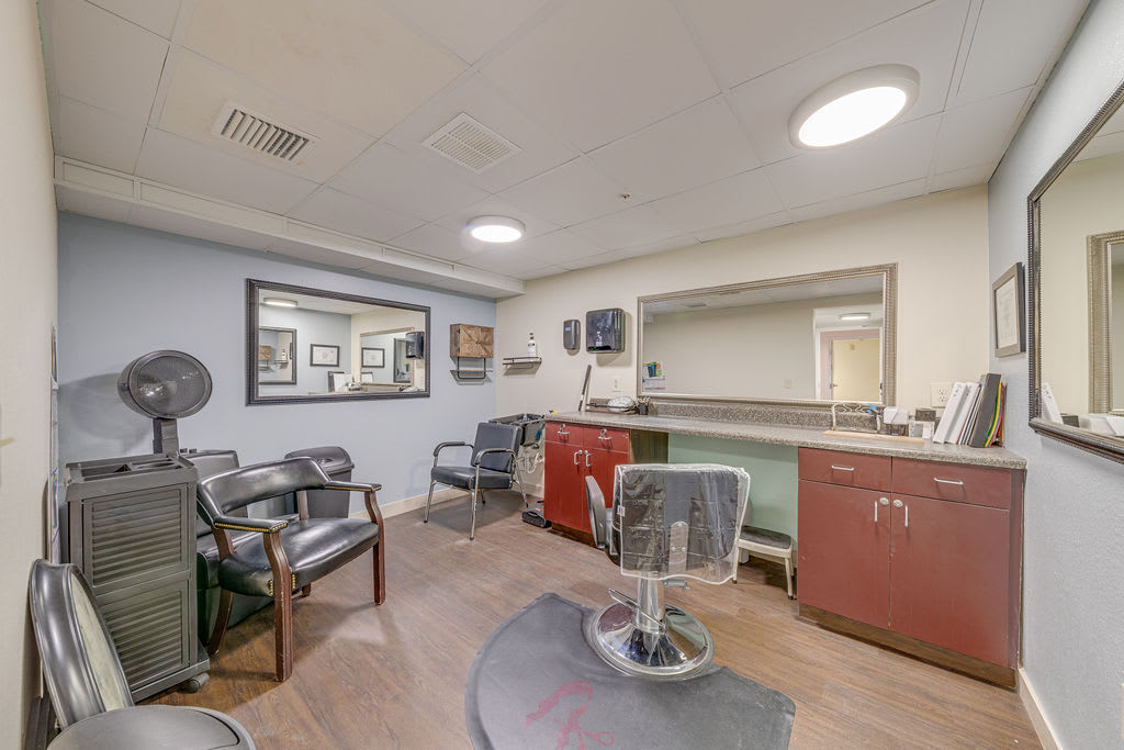 A cozy hair salon interior with styling chairs and a small waiting area.