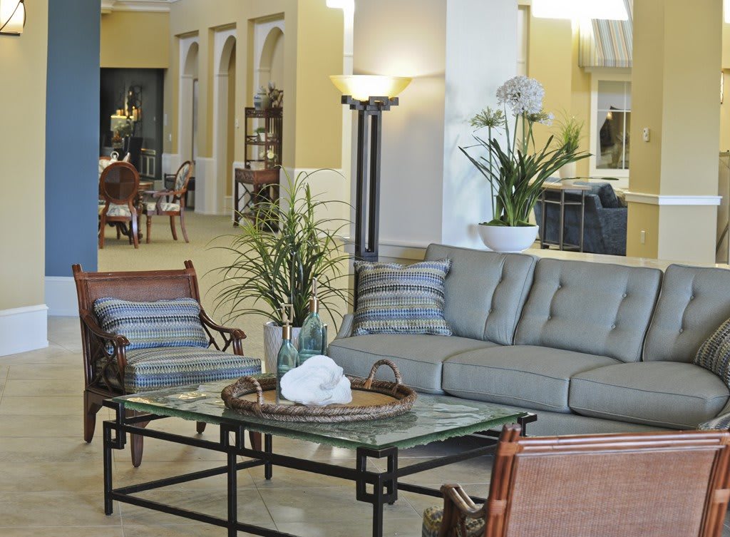 A cozy living room setup featuring a sofa, coffee table, and various plants.