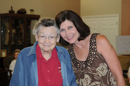 A joyful moment between an elderly woman and a younger woman, showcasing a loving connection.
