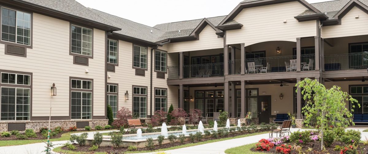 A modern residential building with an outdoor fountain and landscaped garden.