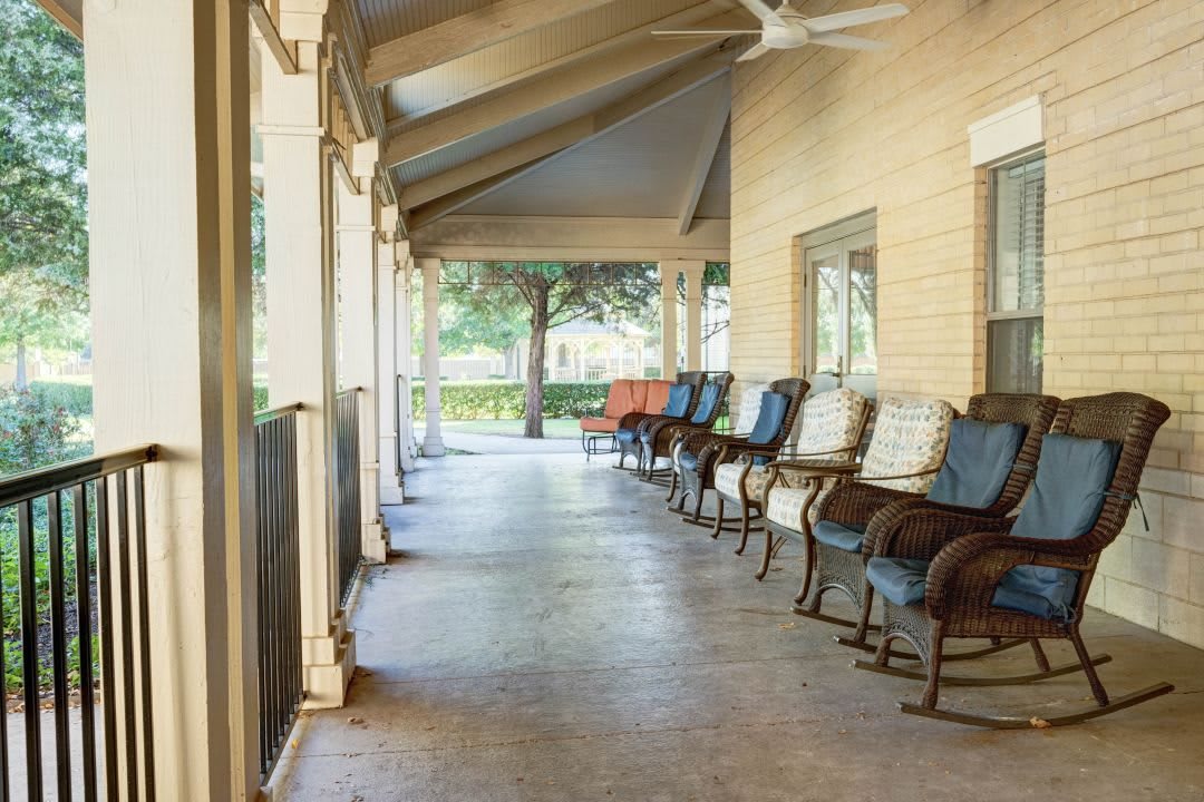 A relaxing veranda with comfortable chairs and a ceiling fan.