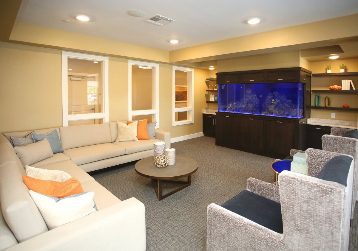 A modern living room featuring a large aquarium, comfortable sofas, and stylish decor.
