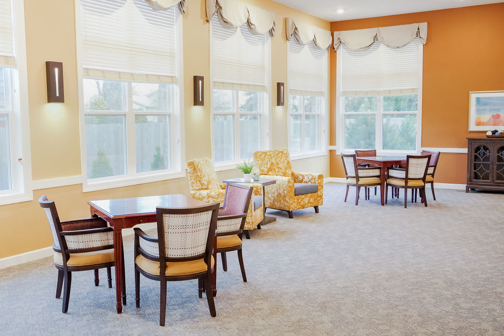 A bright and spacious dining area with tables, chairs, and large windows.