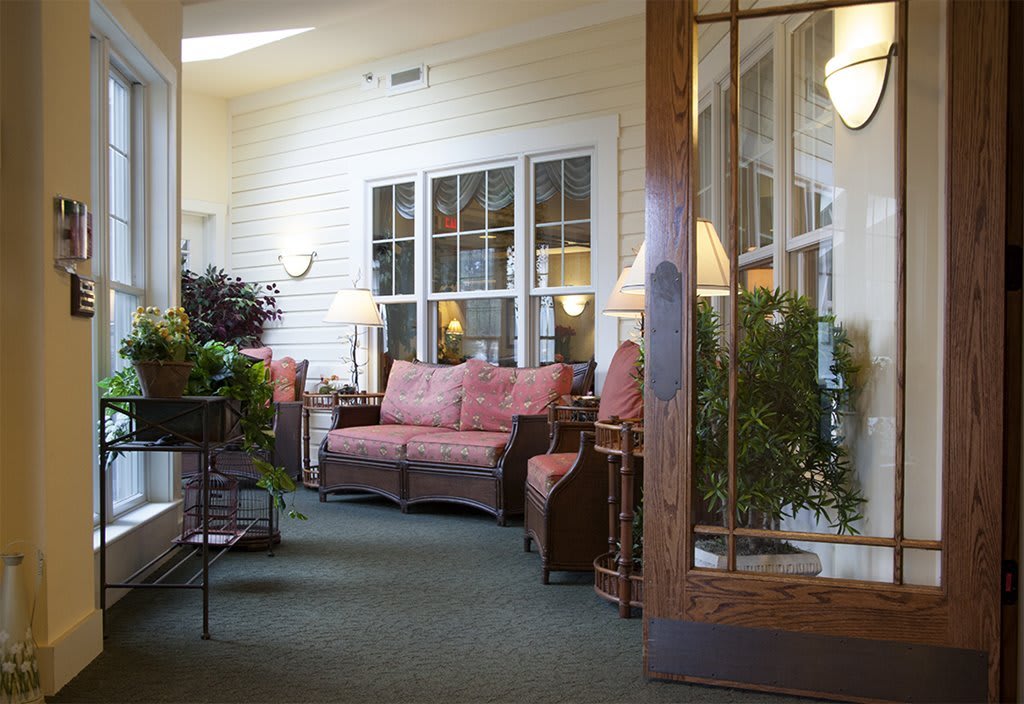 A cozy porch area with comfortable seating and lush plants.