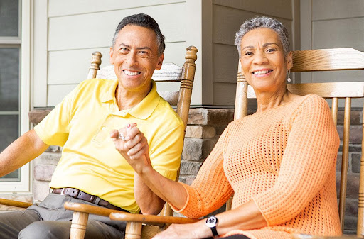 A joyful couple enjoying a relaxing moment together on their porch, sharing smiles and affection.