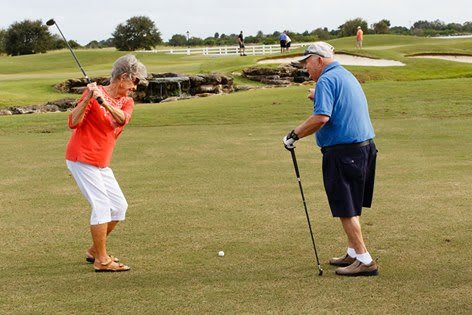 Two seniors enjoying a game of golf on a sunny day.