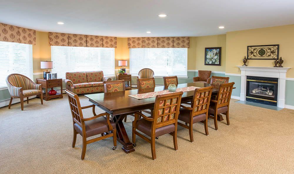 A spacious dining room with a large wooden table and matching chairs.