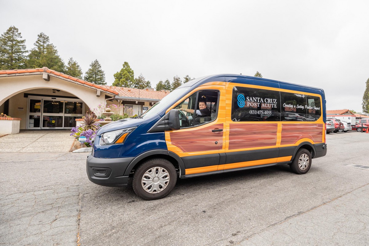 A blue and wooden-themed shuttle van parked outside a building, ready for transportation services.