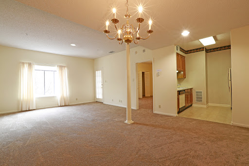 A spacious living room with a chandelier and ample natural light.