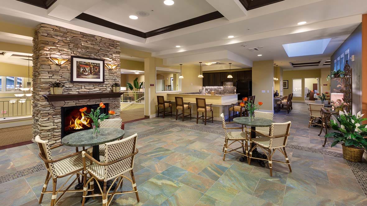 A cozy lobby interior featuring a fireplace, seating area, and bar counter.