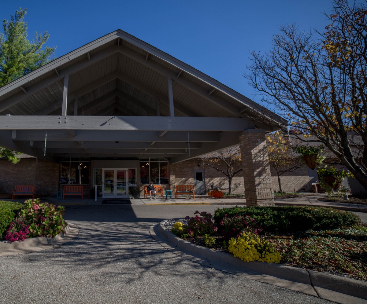 A building entrance surrounded by landscaped greenery and trees.