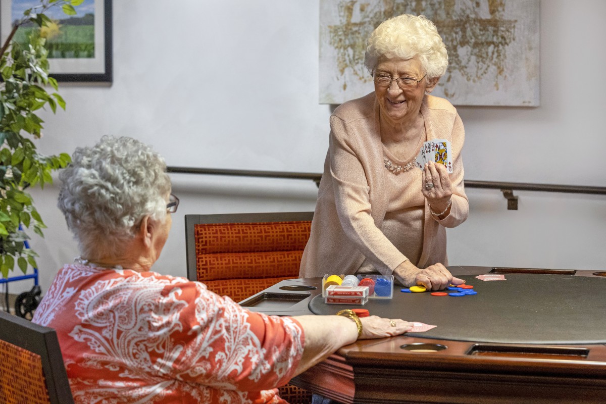 Two senior women enjoying a card game together.