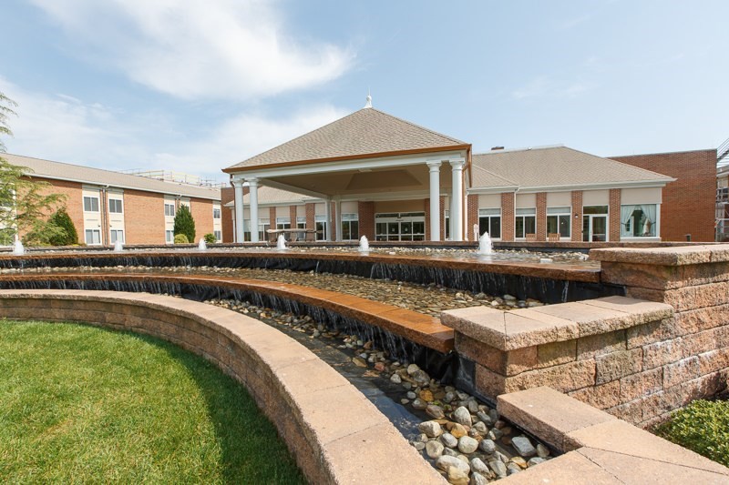 A modern building with a multi-tiered fountain in the foreground.