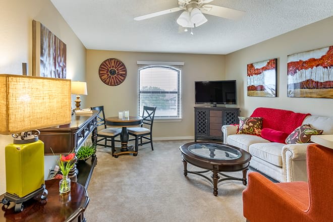 A cozy living room featuring a sofa, television, and dining table with elegant decor.
