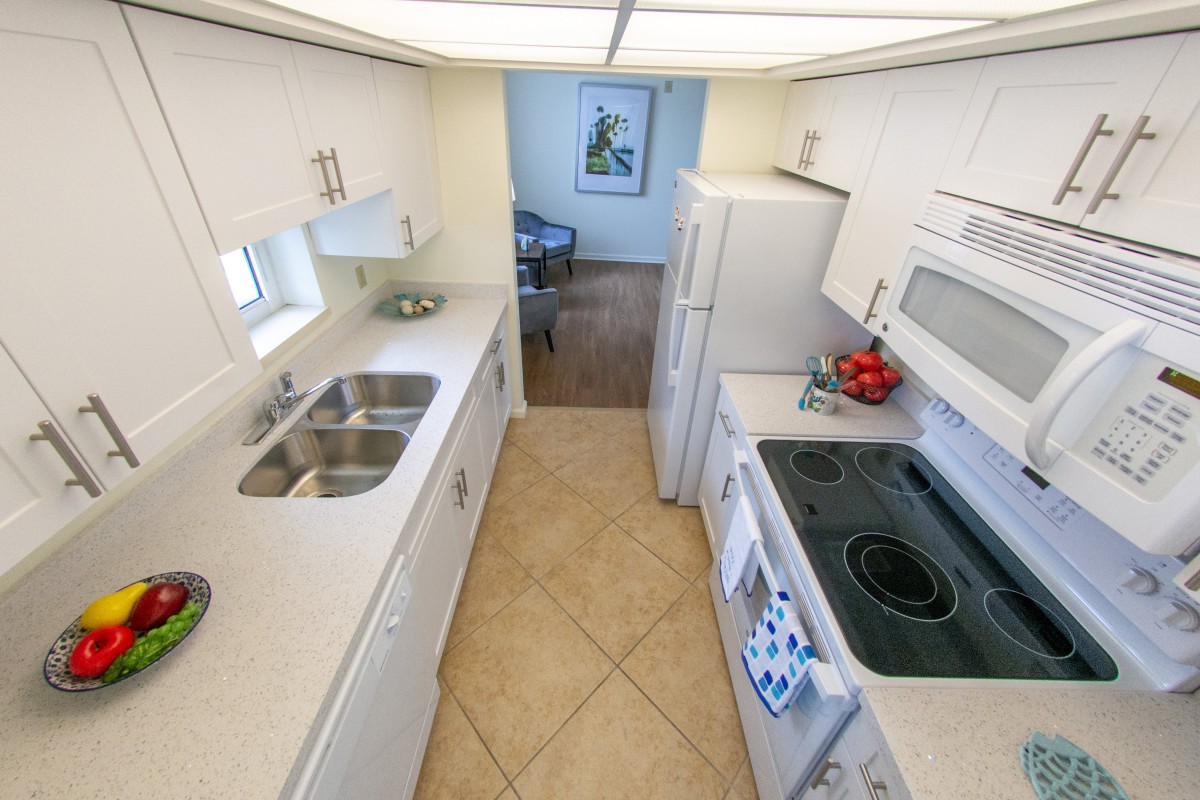 A modern kitchen with white cabinetry and appliances.