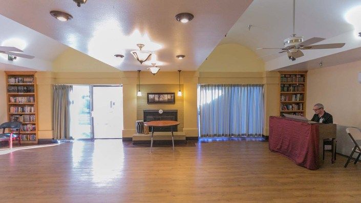 A spacious living room with wooden flooring and elegant lighting.