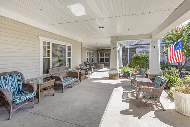A spacious covered patio with wicker furniture for outdoor relaxation.